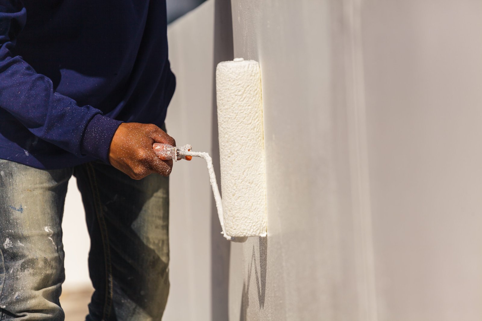 Painter man at work with a paint roller